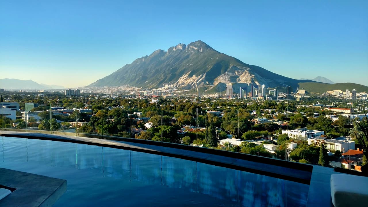 Vista del Cerro de la Silla en Monterrey con un cielo despejado y una piscina en primer plano