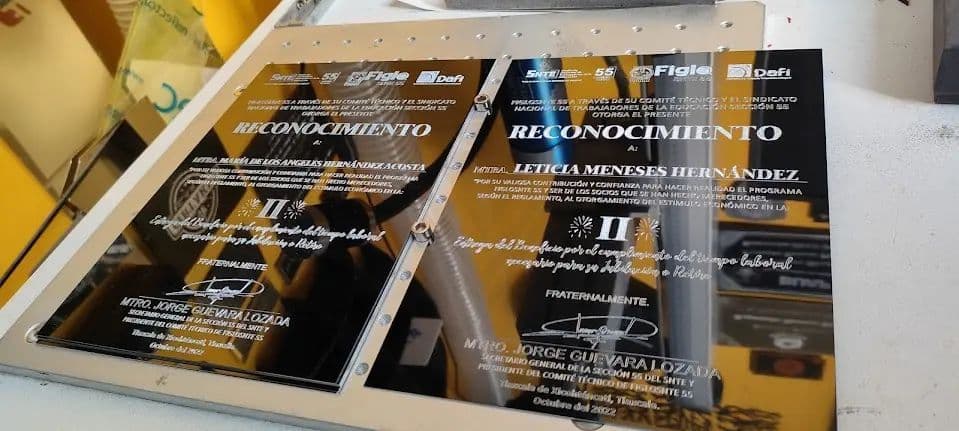 Placas de reconocimiento en acrílico grabadas a láser sobre la mesa del taller