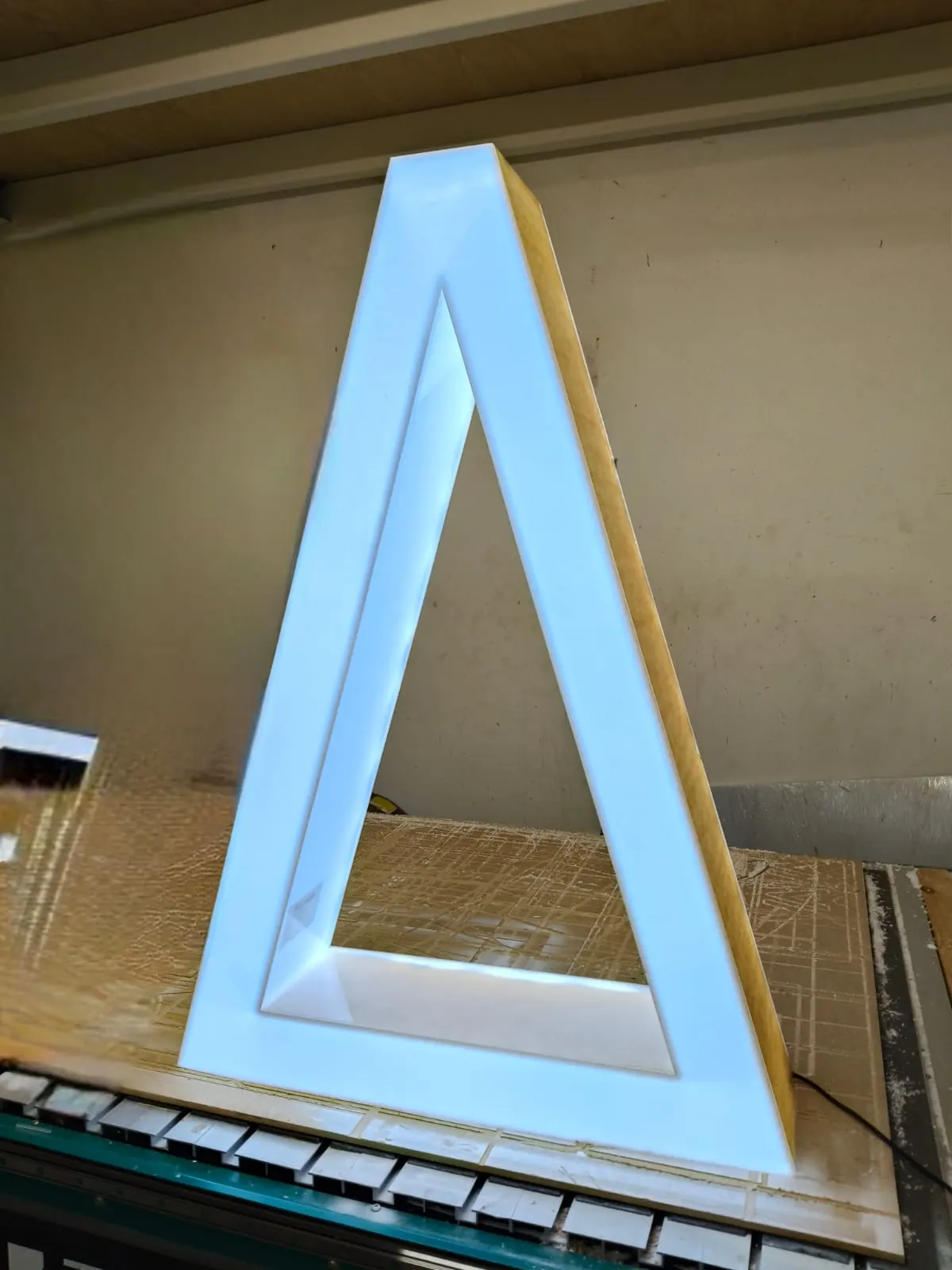 Letra triangular volumétrica con iluminación LED en proceso de armado en el taller