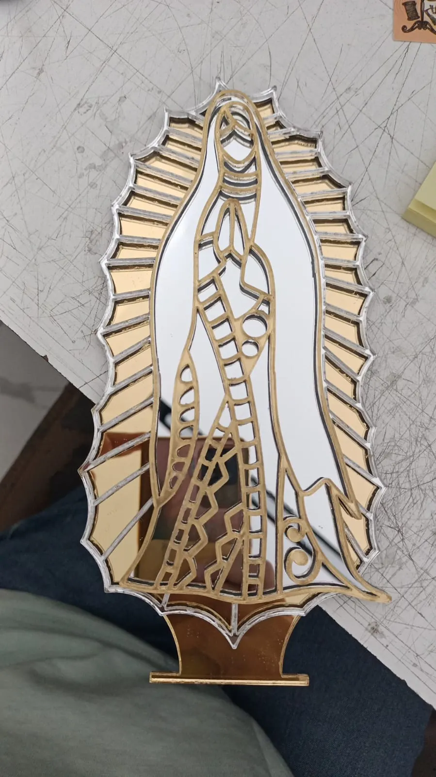 Figura de la Virgen de Guadalupe armada en capas de acrílico espejo dorado y plateado, con base