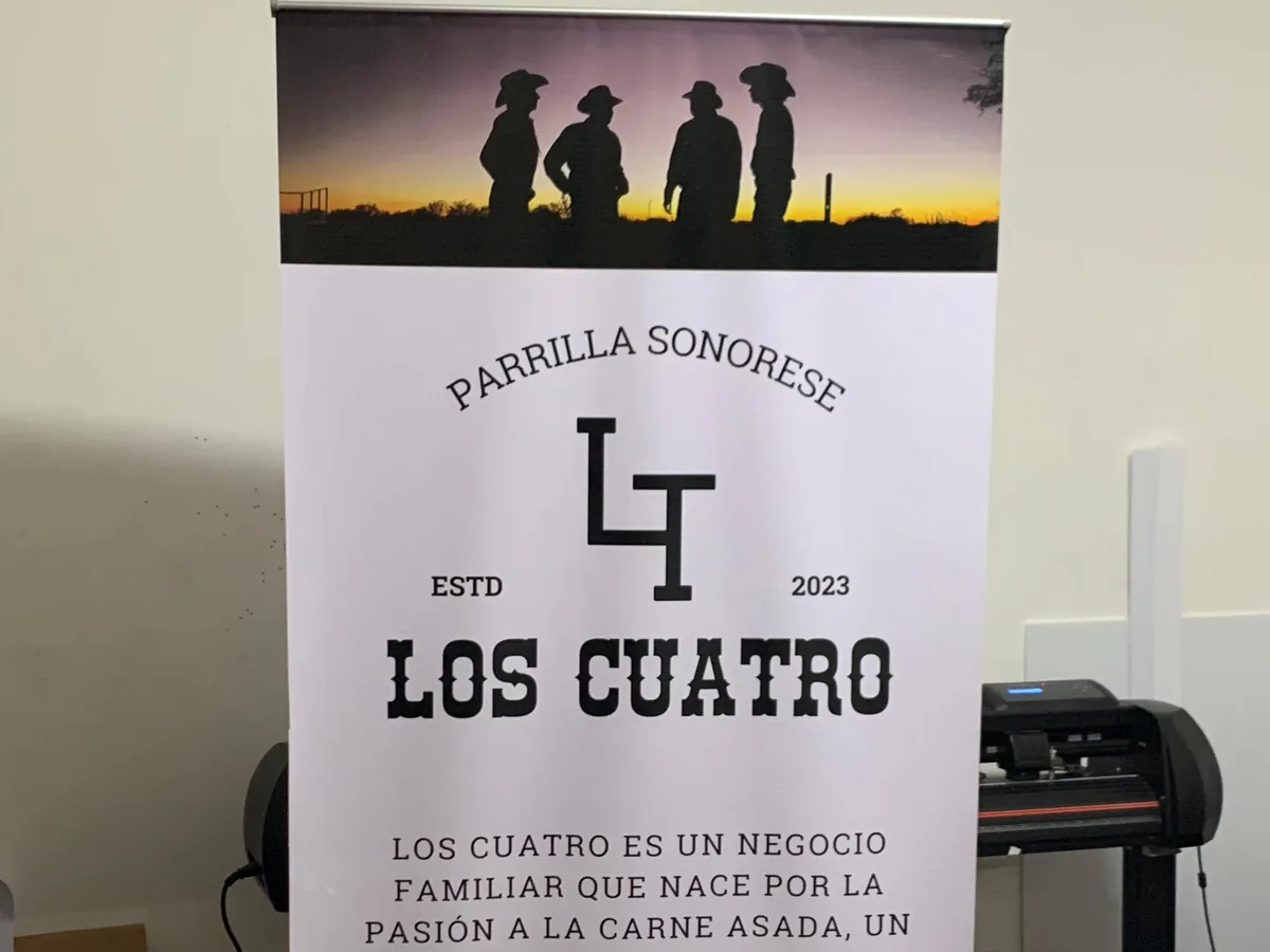Roll-up impreso con el logotipo de una parrilla y una fotografía de siluetas al atardecer, armado en el taller