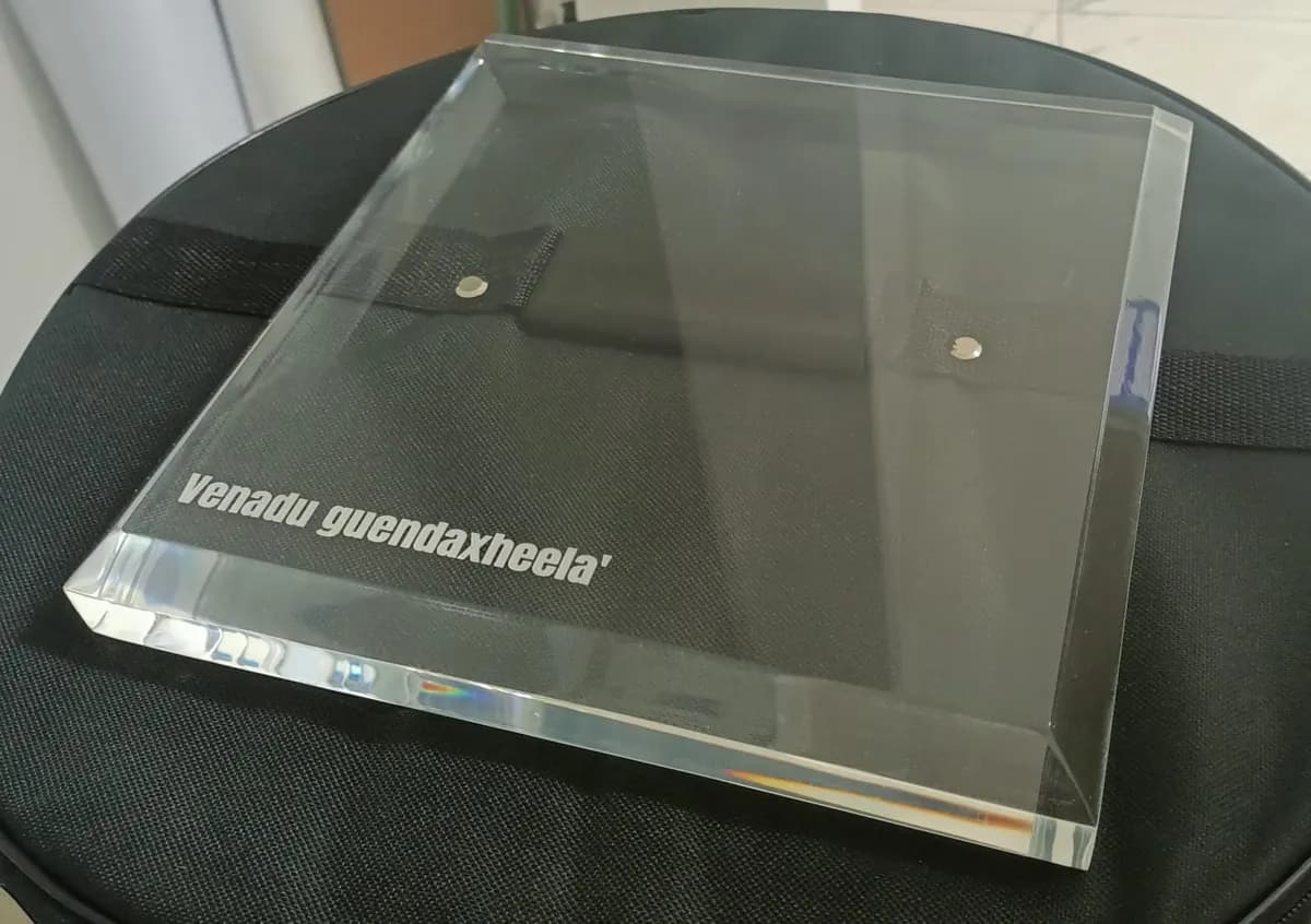 Bloque de acrílico transparente grueso con canto biselado y una leyenda grabada con láser en la esquina