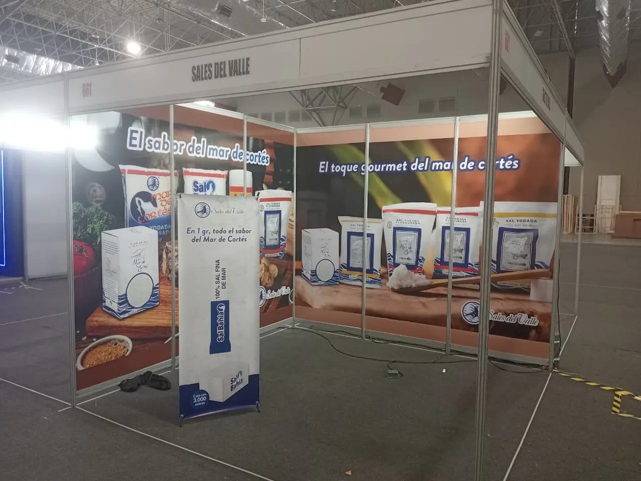 Stand de exposición con paneles impresos y banner tipo X instalados en un centro de convenciones