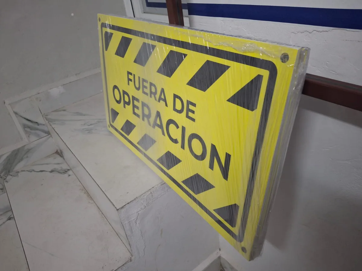 Señalamiento rígido amarillo con la leyenda Fuera de operación y franjas negras, emplayado antes de entregarse