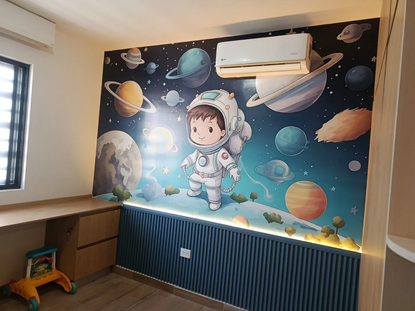 Mural de vinil impreso con astronauta y planetas en la pared de una habitación infantil
