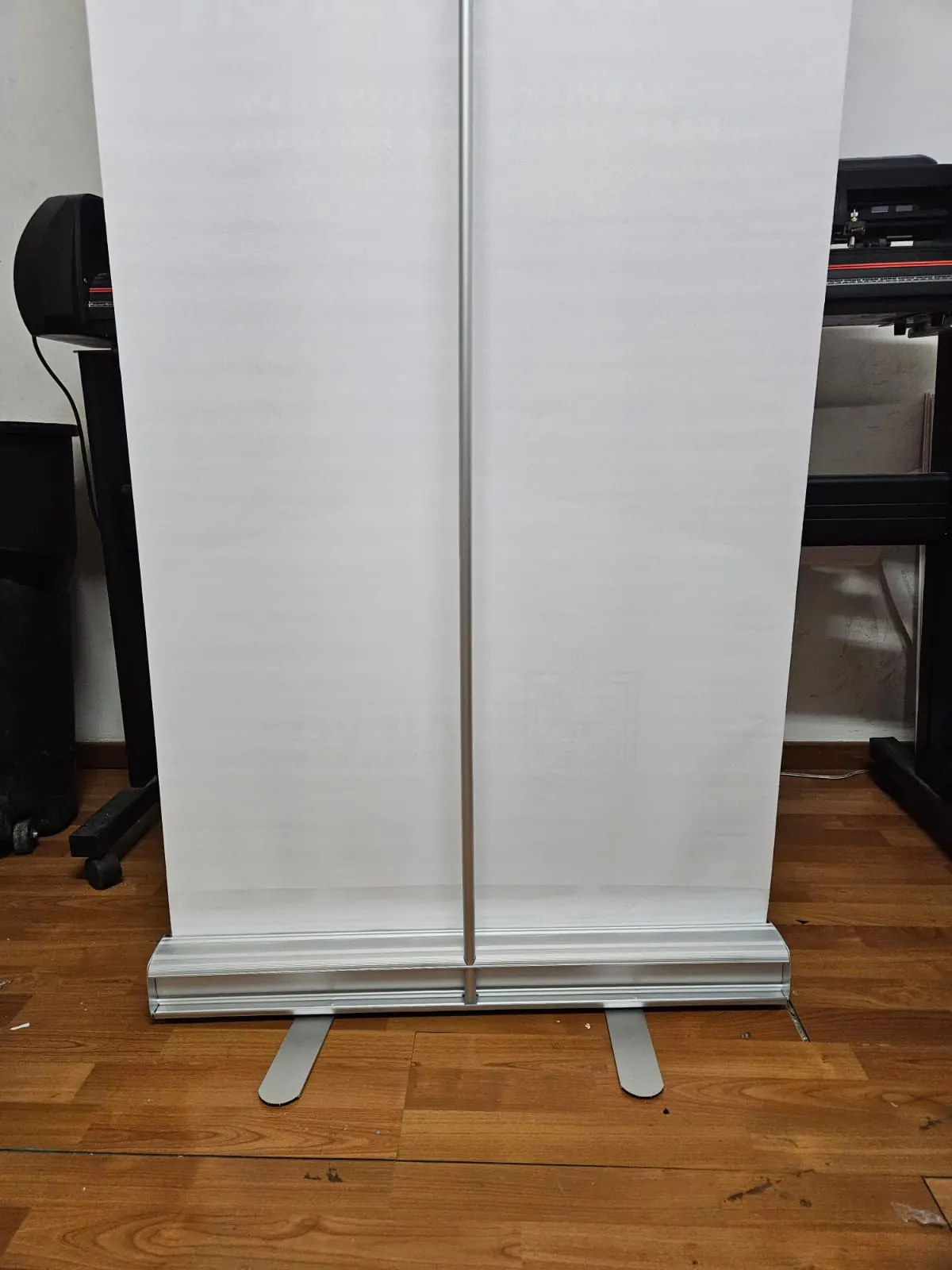 Estructura de roll-up con base de aluminio y lona en blanco, armada en el taller antes de imprimir